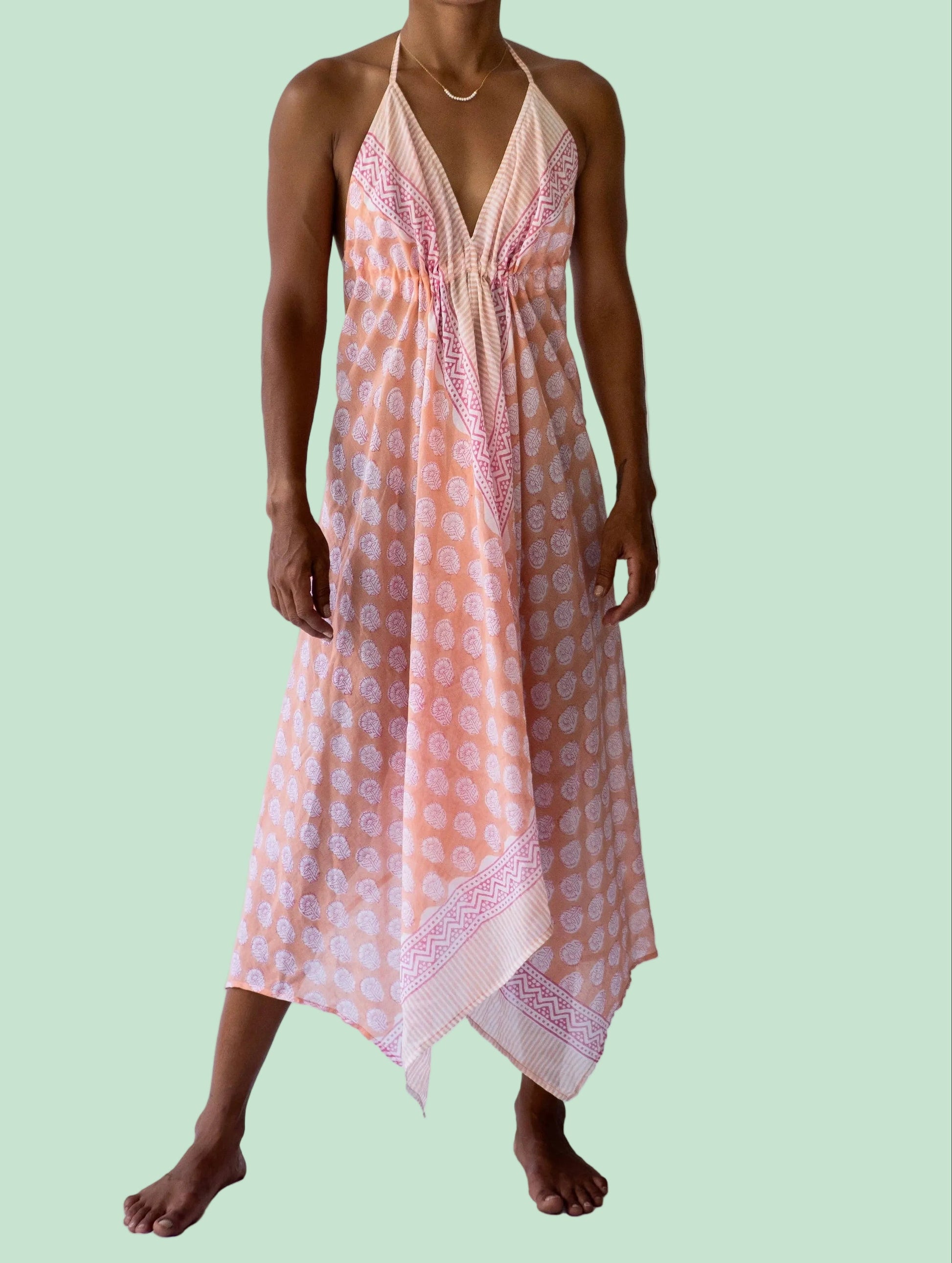 Woman wearing a pink and orange patterned dress on a white background