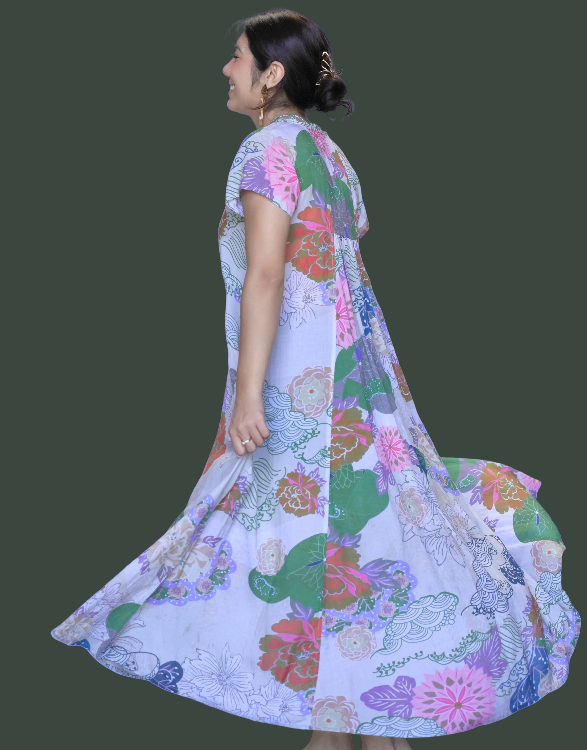 Woman wearing a colorful floral dress against a white background