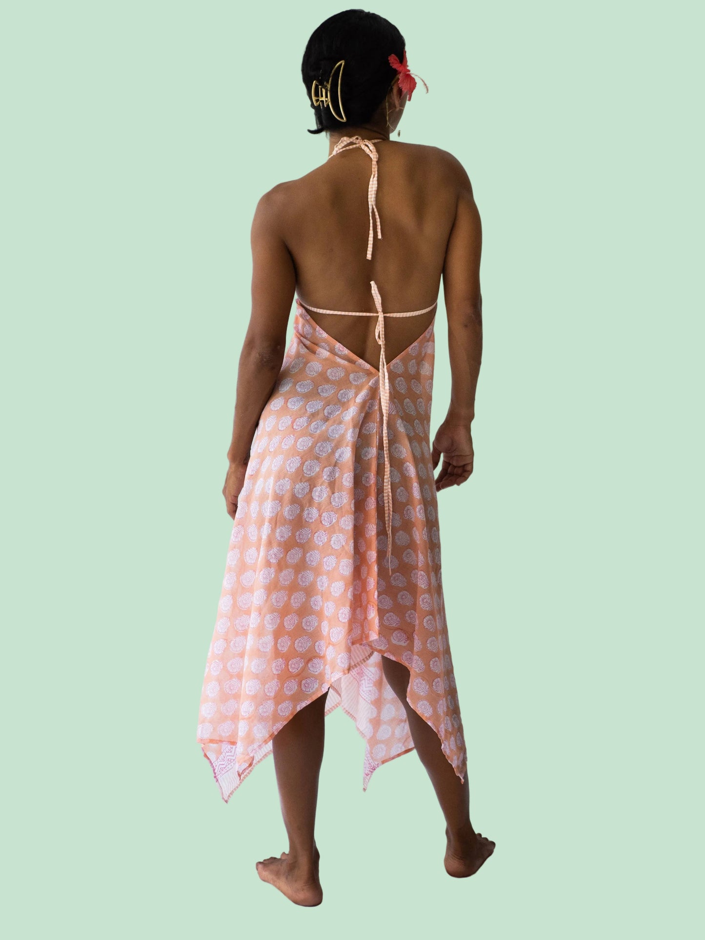 Woman wearing a pink and white patterned dress on a white background
