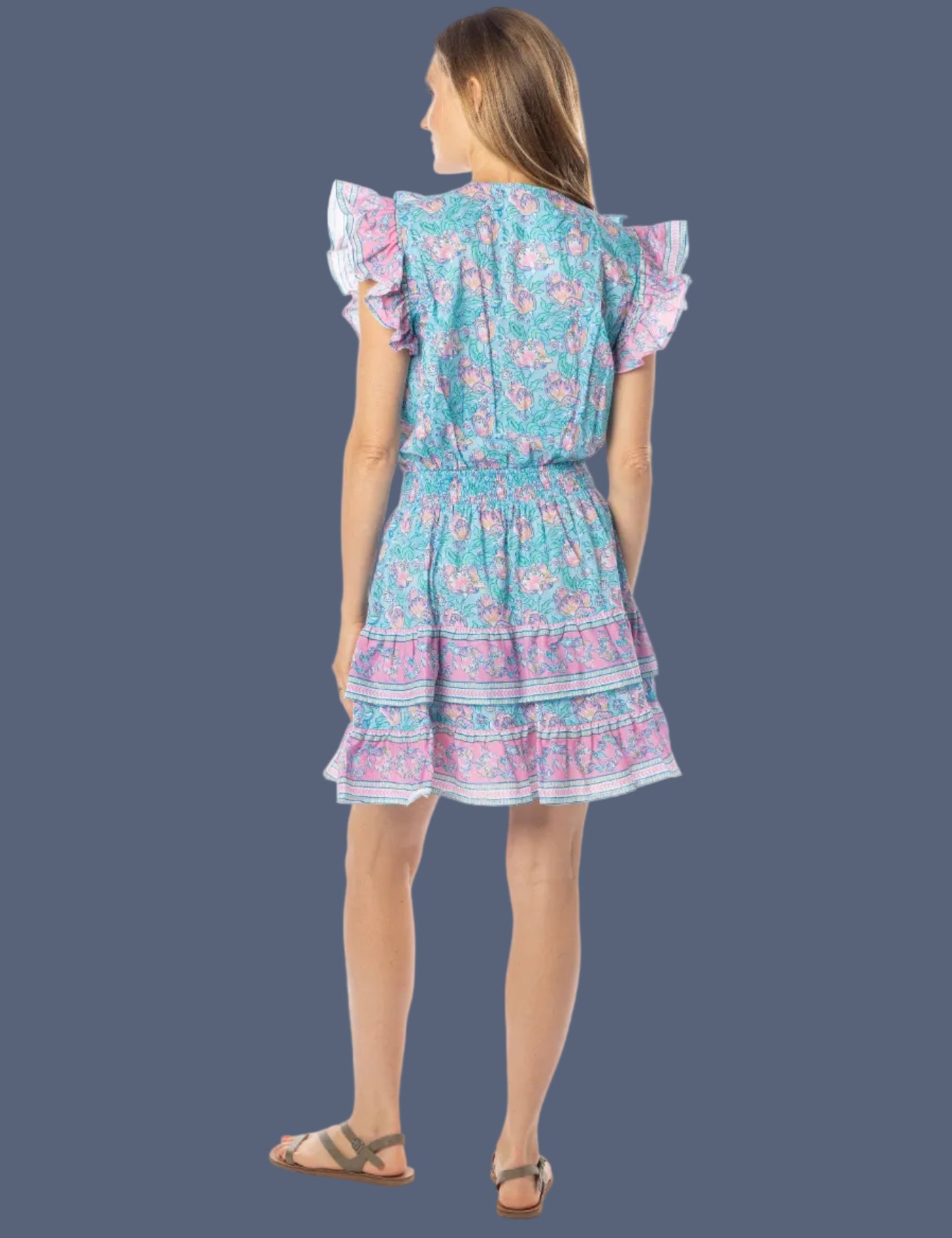 Woman wearing a colorful dress with ruffled sleeves on a white background
