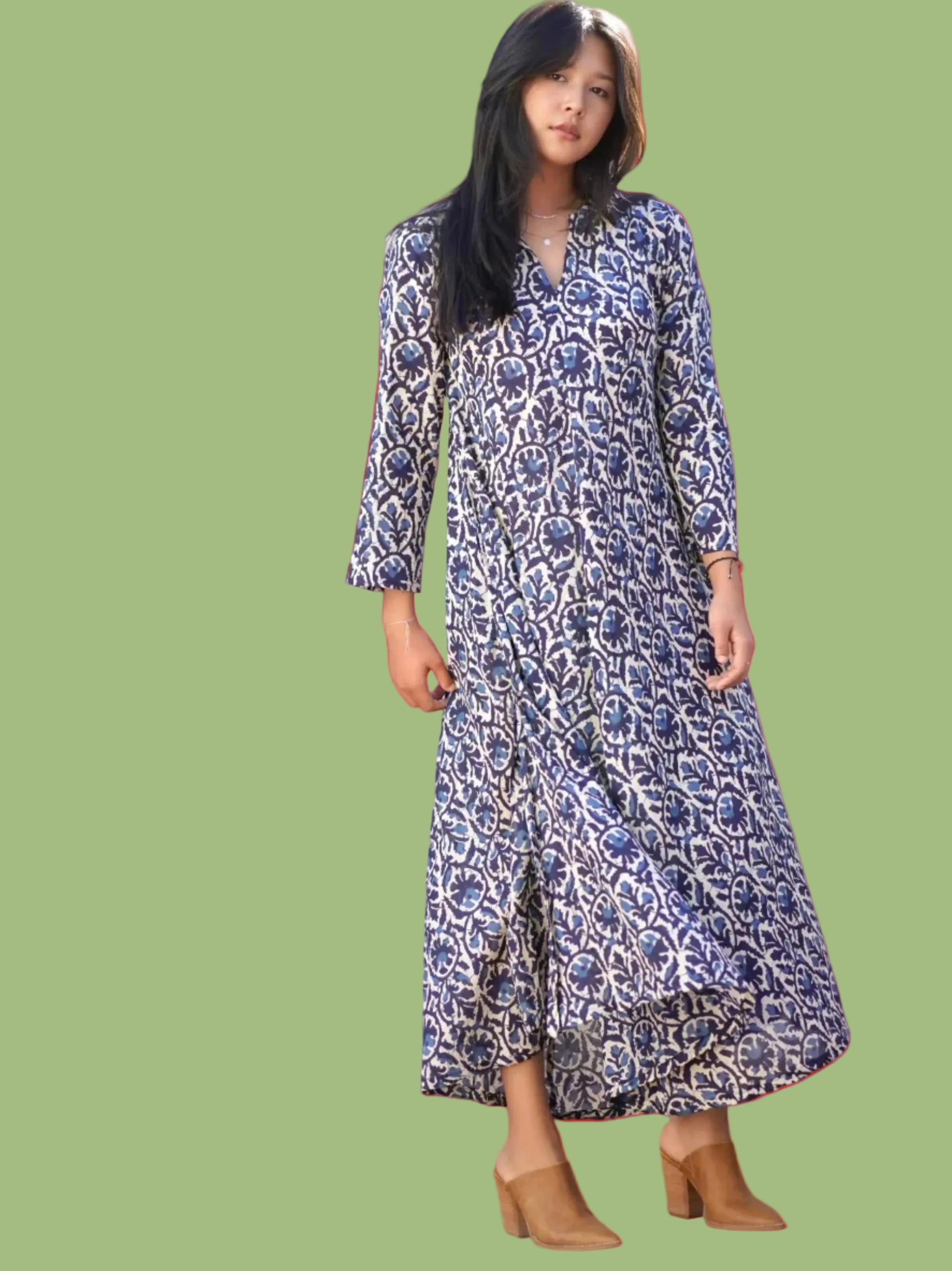 Woman wearing a blue patterned dress standing outdoors.
