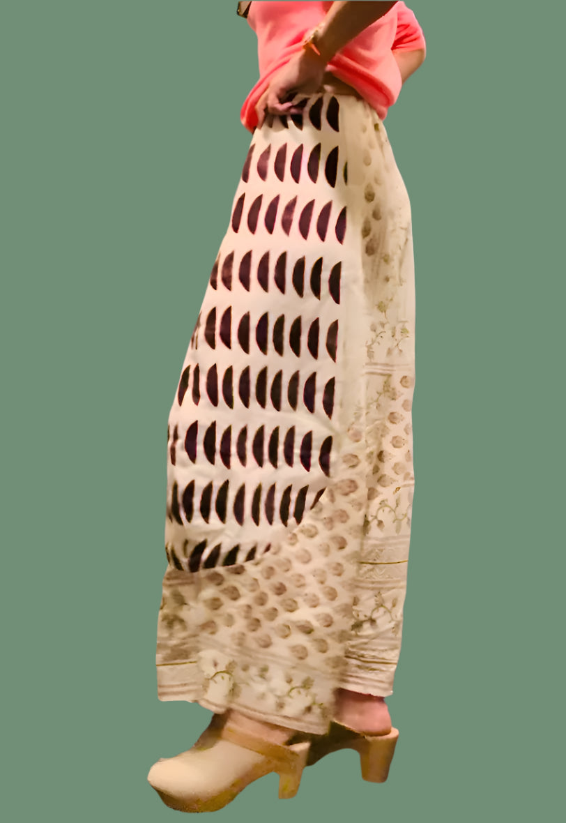 A pair of beige linen pantalons with geometric blockprint patterns, featuring a mid-rise waist and ankle length.