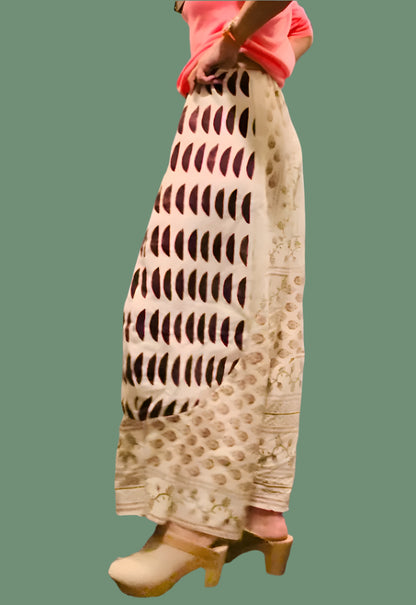 A pair of beige linen pantalons with geometric blockprint patterns, featuring a mid-rise waist and ankle length.