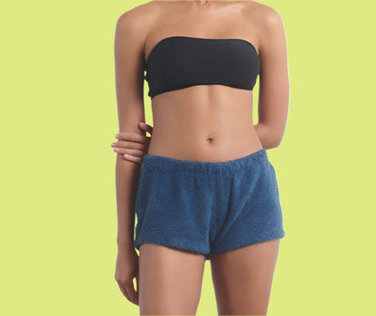 A person standing wearing blue shorts and a black sports top.